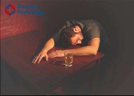 Последствия алкоголизма Мужчина за столом со стаканом алкоголя